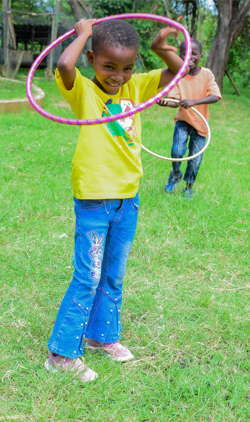 Kind in Kenia spielt mit einem Hulahoop.