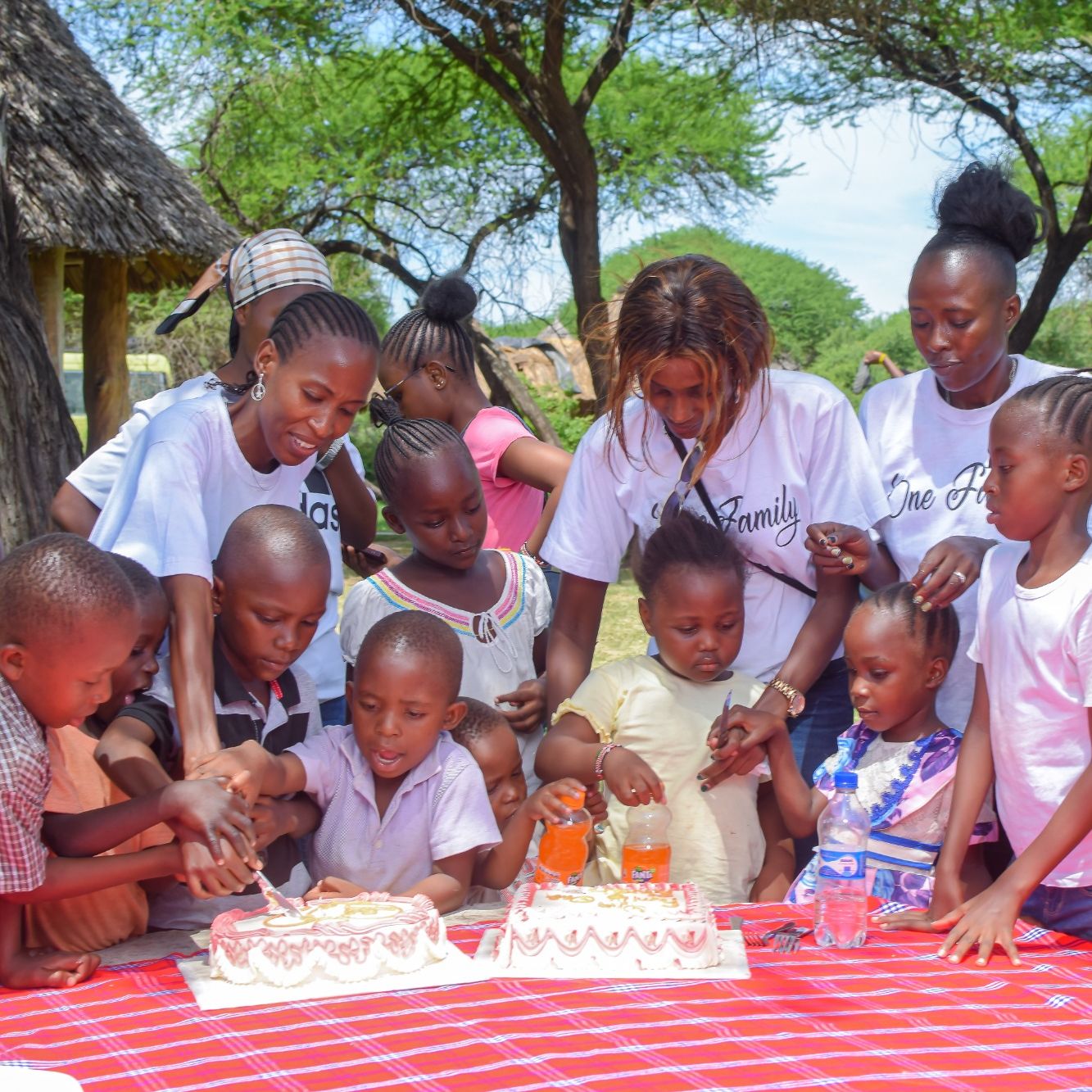 Die Frauen in Kenia von One Family One Earth schneiden mit den Kindern eine Torte an